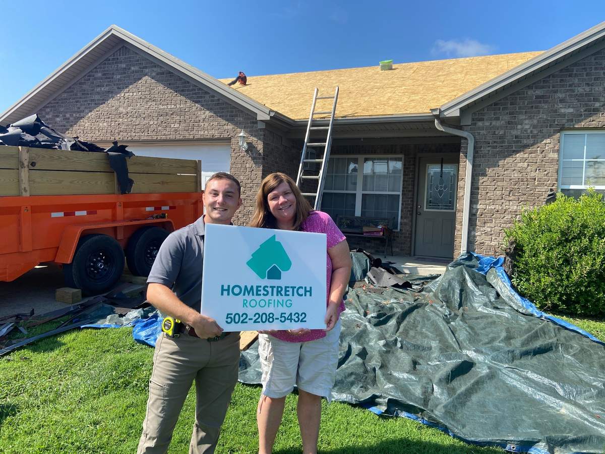 Homestretch Roofing team with happy customer after roof replacement